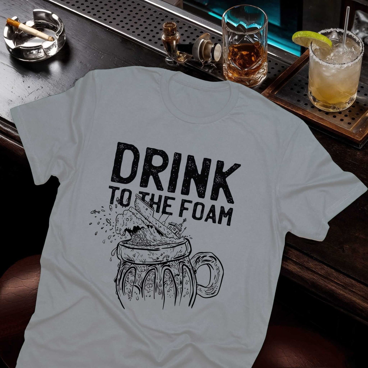 Casual beer design with worn-effect "Drink to the Foam" text and hand-sketched frothy beer glass design on the gray t-shirt