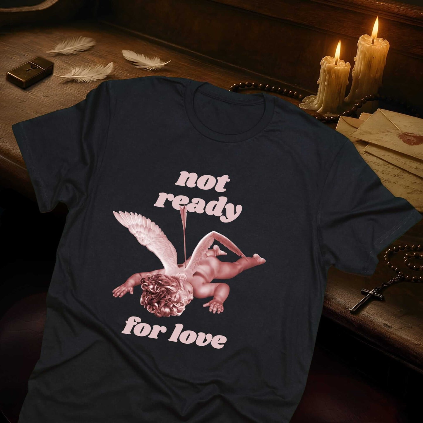 Black t-shirt displaying wounded cherub illustration with spread wings and arrow, anti-Valentine's Day design by Vice & Tees
