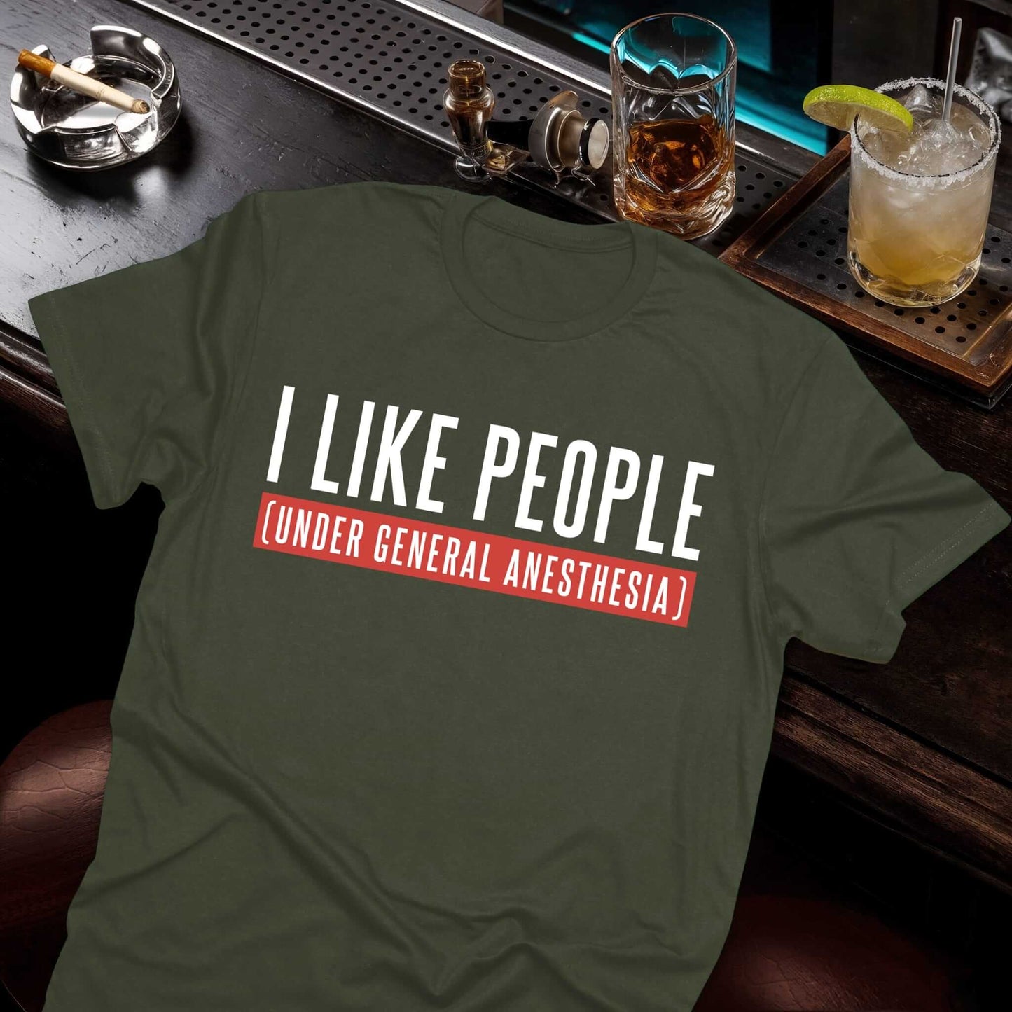 A green t-shirt displaying a sarcastic medical phrase about doctors liking people only when they're UNDER GENERAL ANESTHESIA