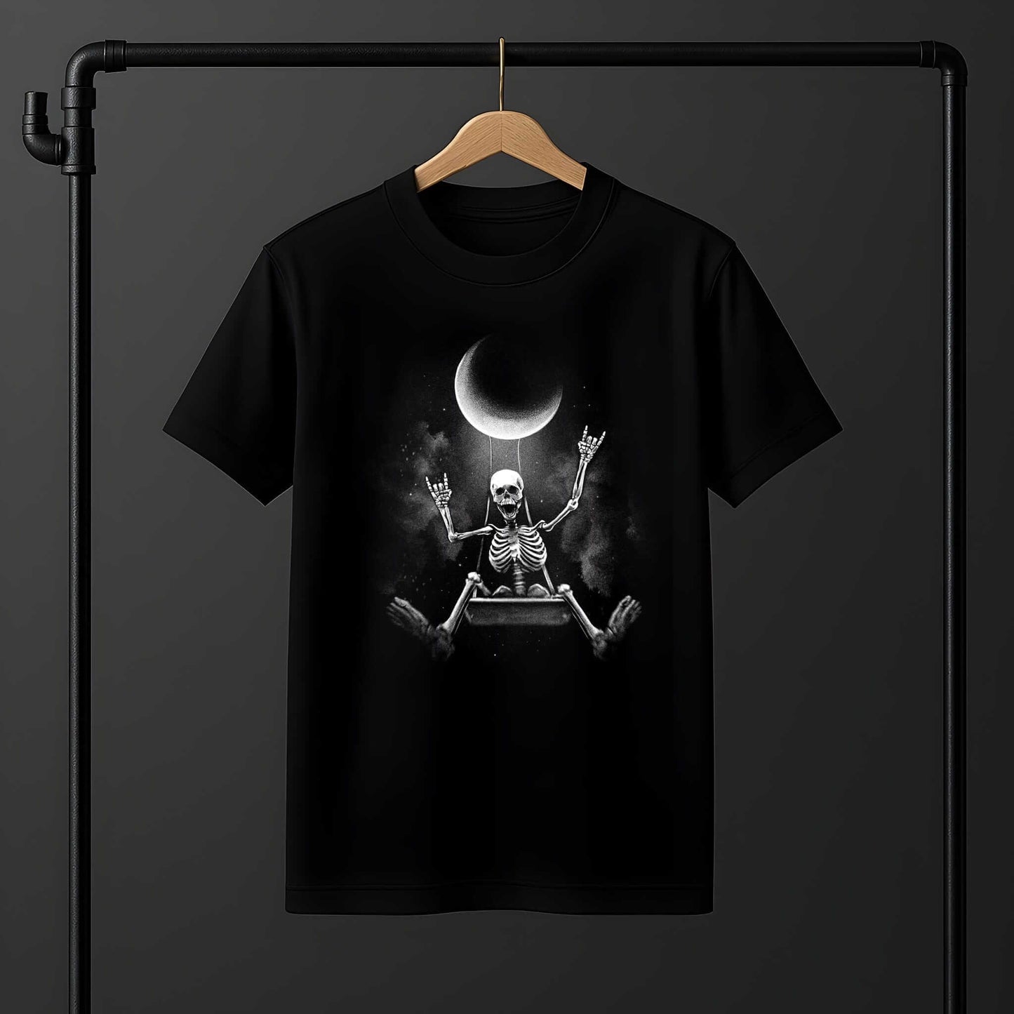 Skeleton sitting cross-legged with arms raised celebrating under crescent moon in spooky Halloween design on a black t-shirt.