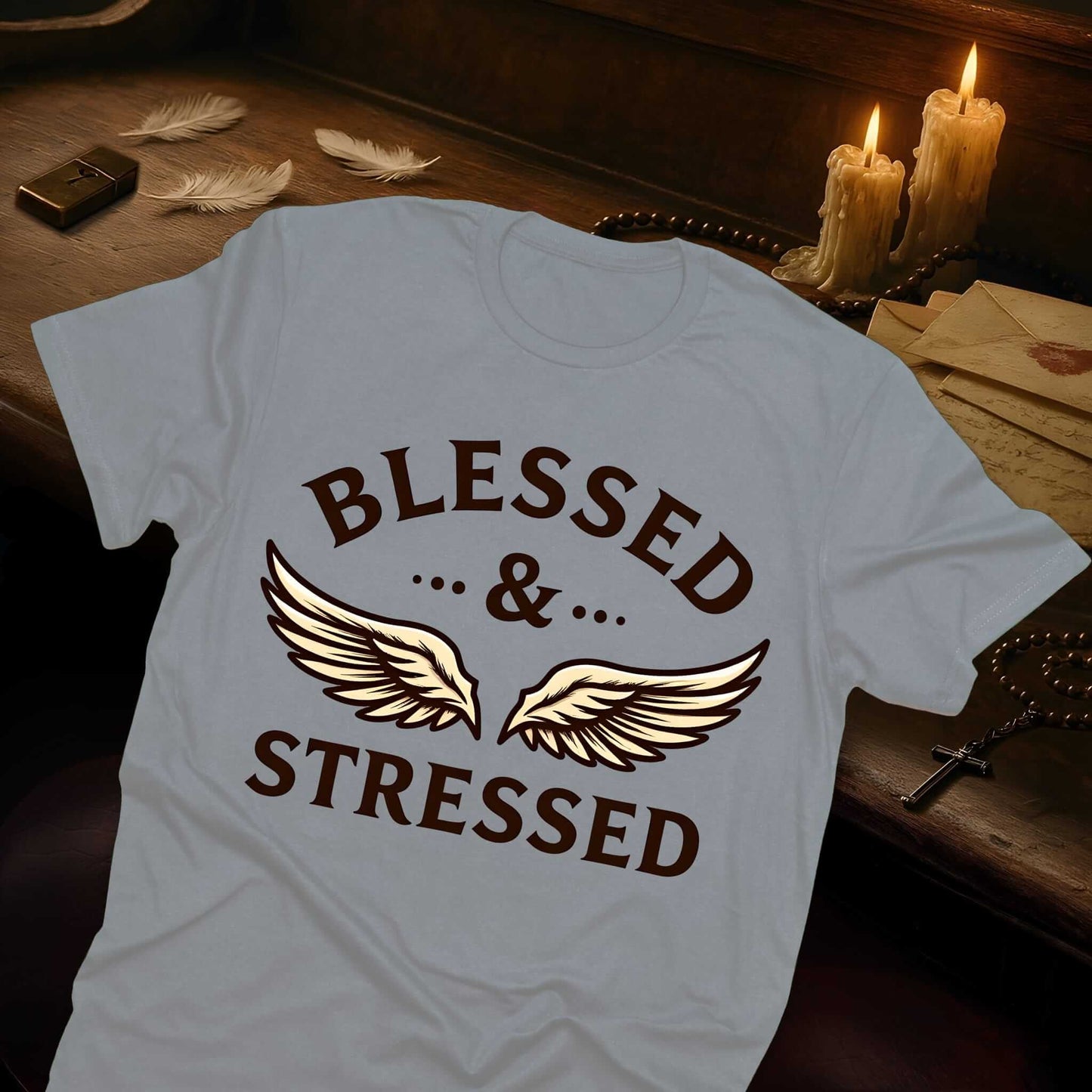 Heather gray t-shirt bearing "BLESSED & STRESSED" inscription in dark lettering with ornate wing flourishes as accent