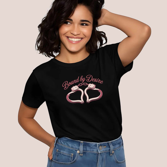 Rose-colored Bound by Desire lettering with a pink heart-shaped handcuff design on a black women's shirt by Vice & Tees.