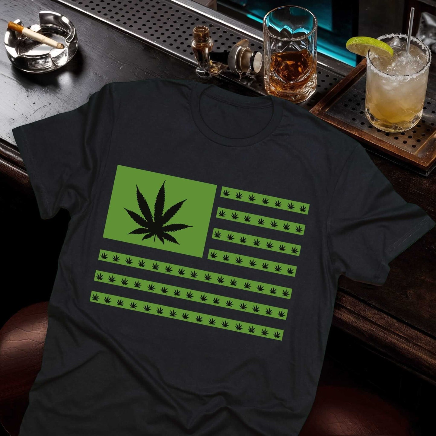 Black t-shirt featuring an American flag design made of green cannabis leaves replacing stars and stripes.