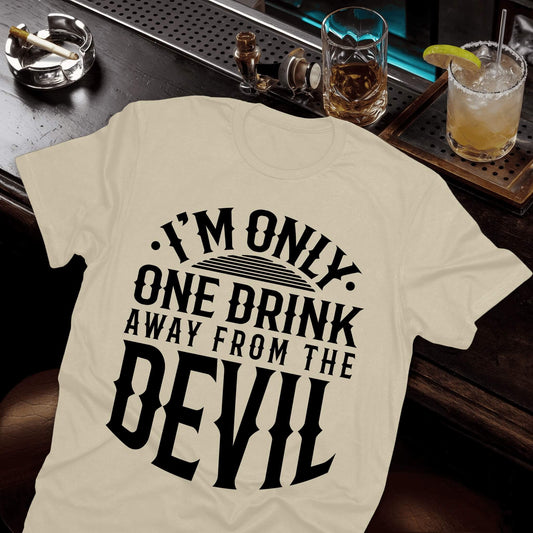 Beige colored t-shirt with "I'm Only One Drink Away From The Devil" phrase in bold black letters and mixed font styles