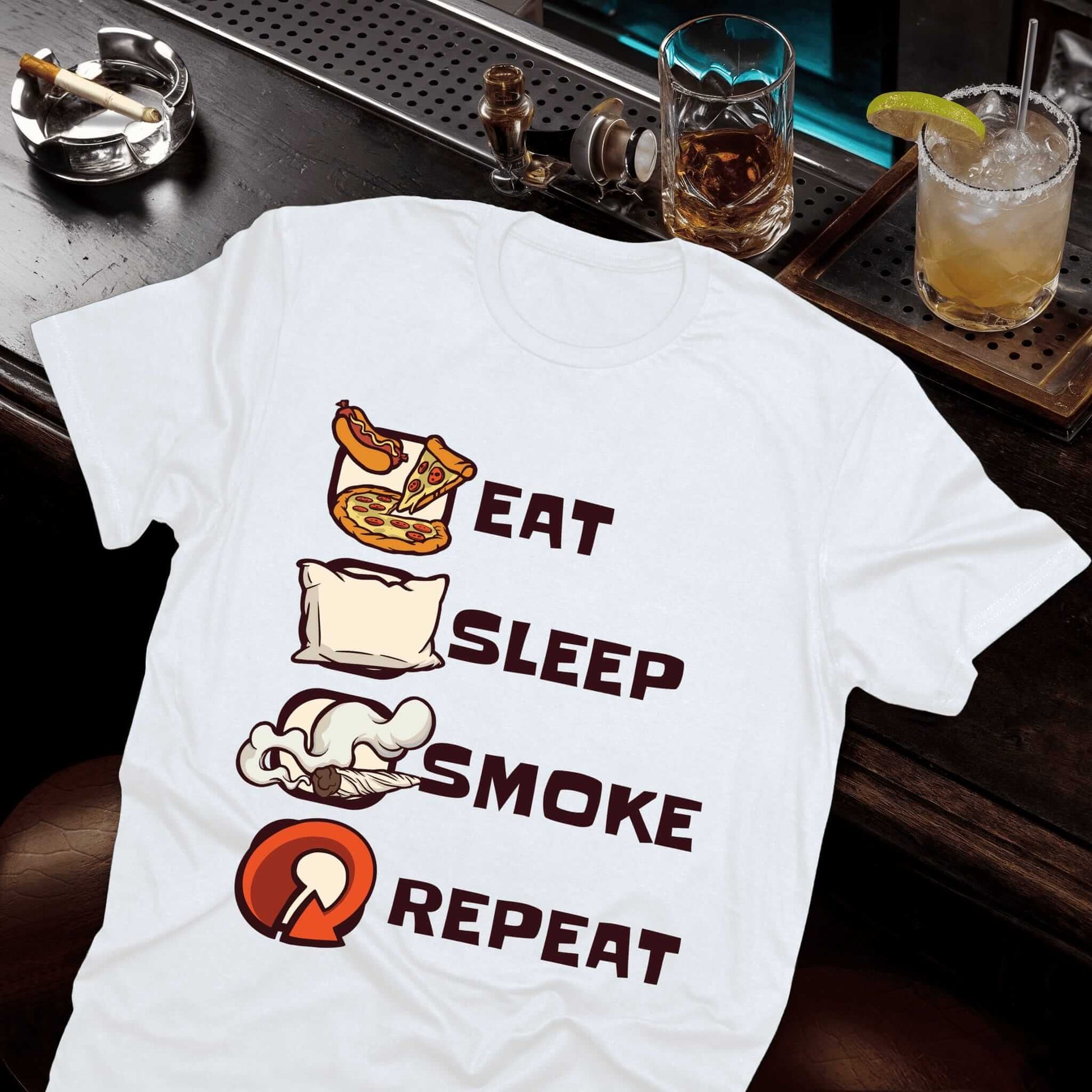 Casual white t-shirt featuring "Eat Sleep Smoke Repeat" slogan with illustrated food, sleep, smoking, and repeat symbols