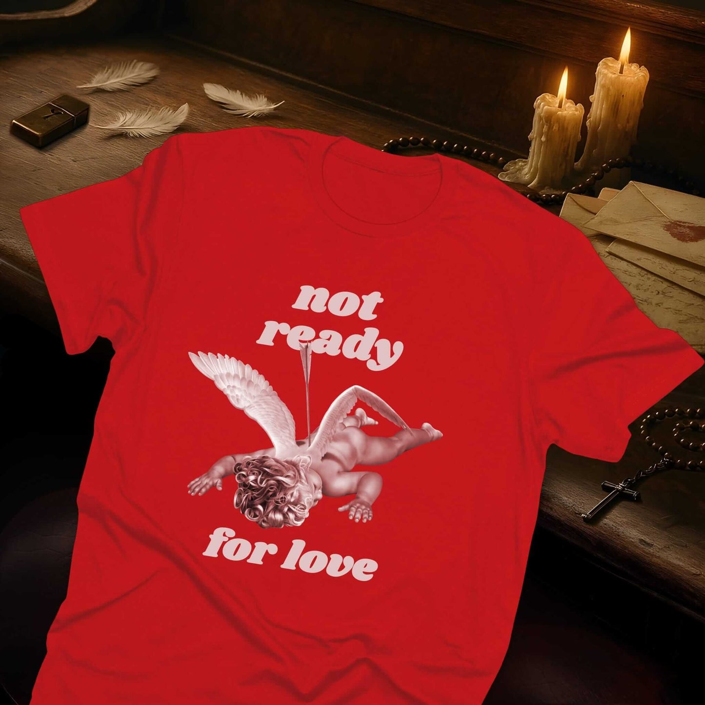 Red t-shirt with "Not ready for love" text and a cupid with an arrow pierced through it, lying face down with wings spread