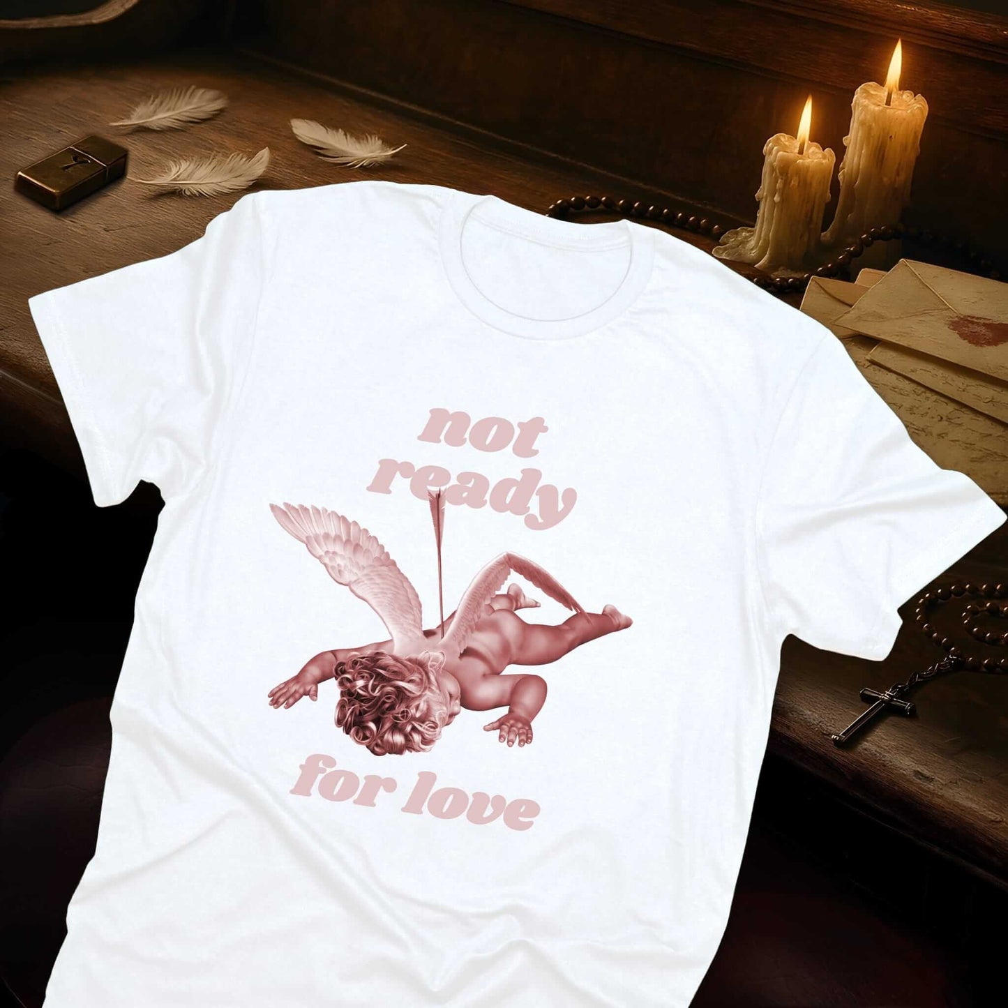 White t-shirt featuring fallen cupid design with arrow through body, wings outstretched, anti-Valentine's Day theme design