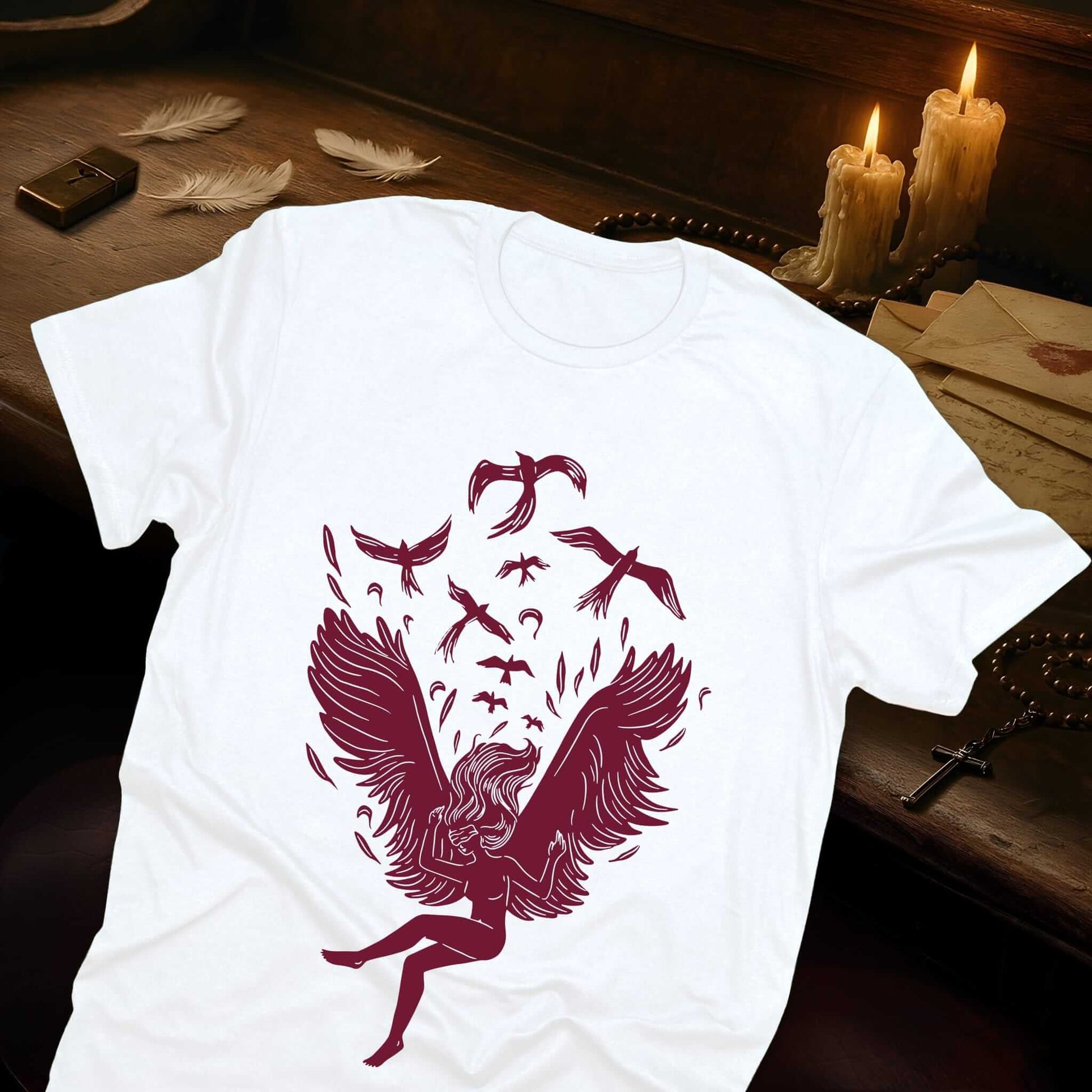 A fantasy fallen angel creature with powerful wings in burgundy line art, showcasing mythical divine imagery on the white tee