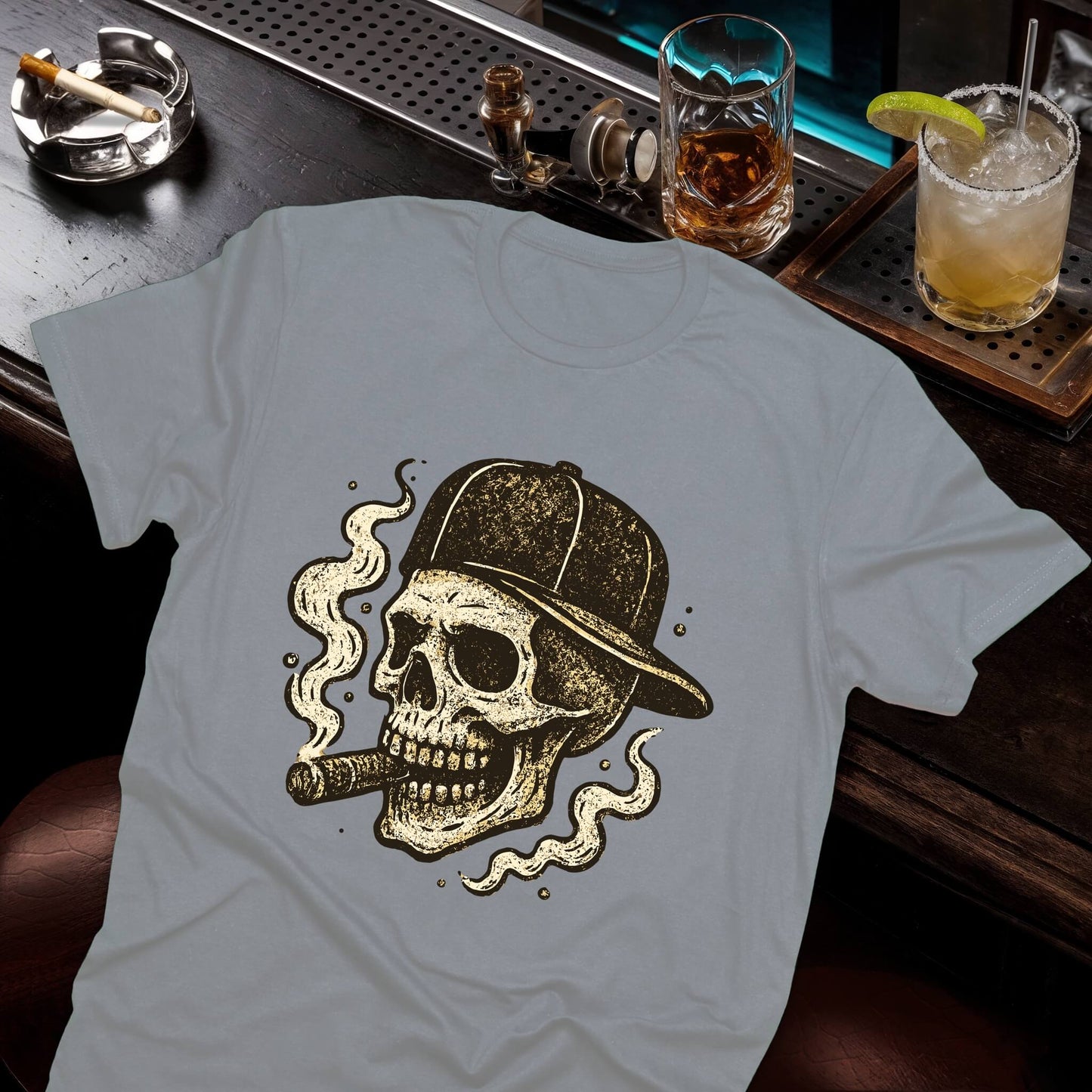 Distressed skull design sporting baseball hat while smoking, accented with decorative smoke swirls in vintage print, gray tee