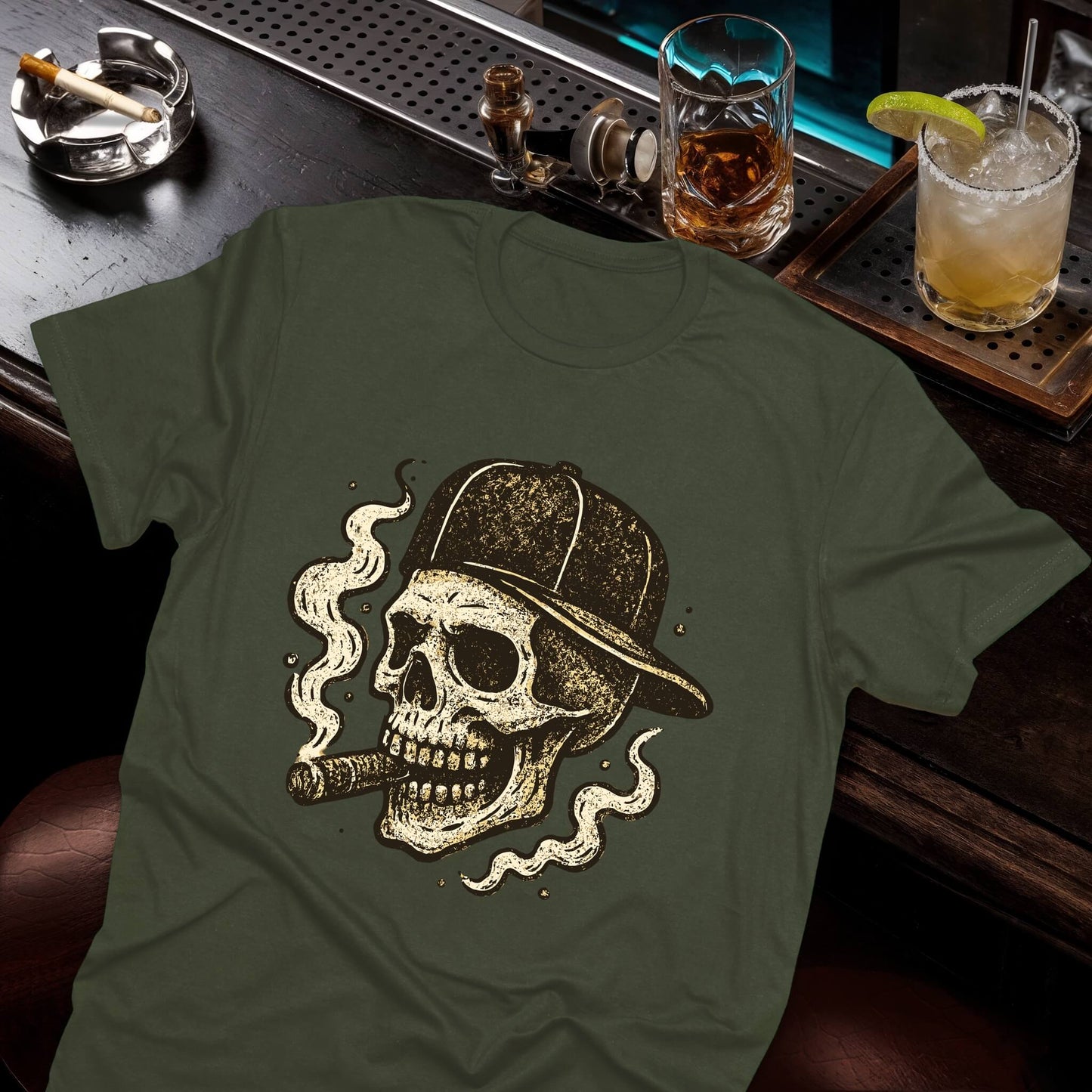 Vintage skull wearing baseball cap with cigar, surrounded by swirling smoke clouds in distressed sepia tones on the green tee