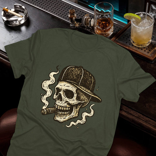 Vintage skull wearing baseball cap with cigar, surrounded by swirling smoke clouds in distressed sepia tones on the green tee