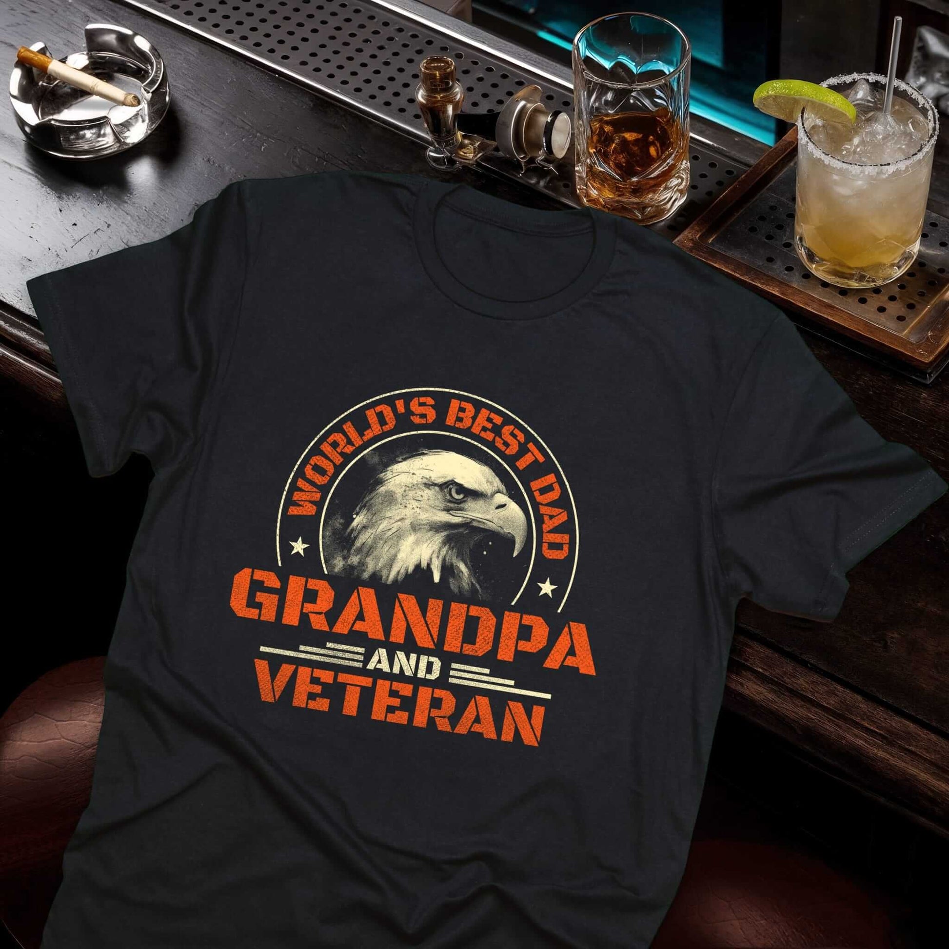 Black tee with orange "World's Best Dad,  Grandpa and Veteran" text surrounding bald eagle head in circular design with stars